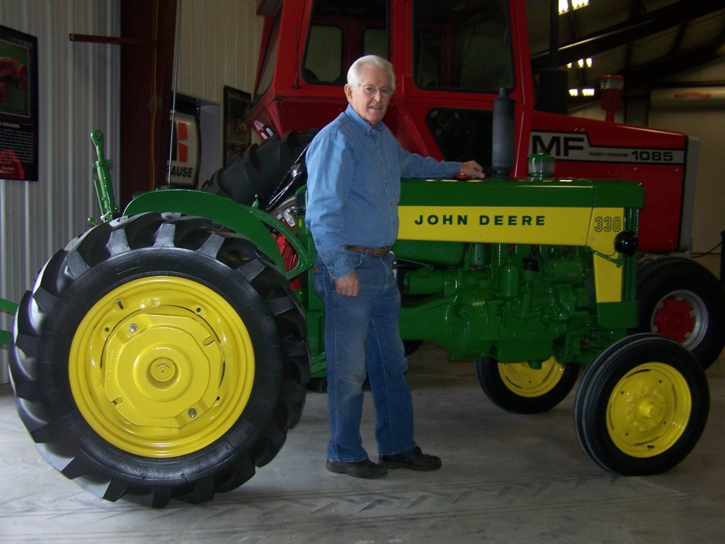 John Cannon by one of his many prized John Deere restored tractors.
